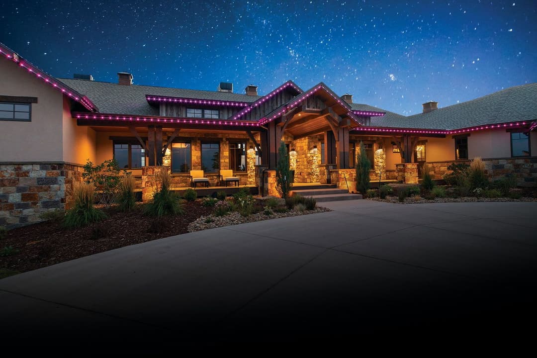 Luxury home exterior at night with vibrant purple LED lights and starry sky.